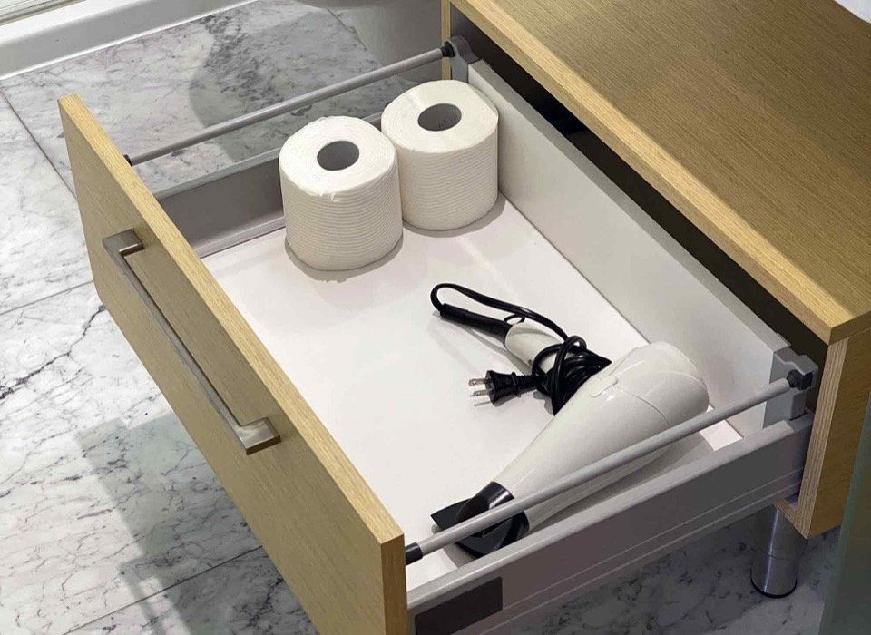 Bathroom drawer with hair dryer and toilet paper